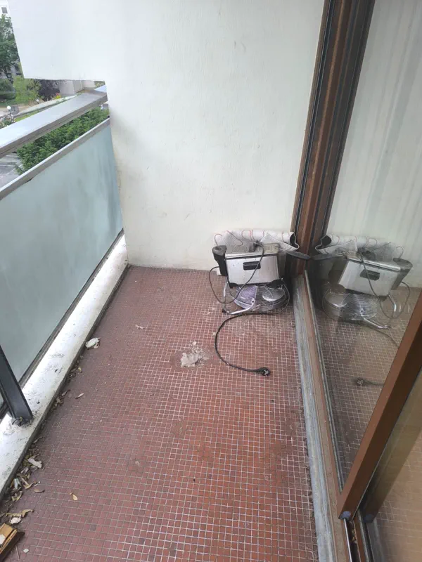 Balcon carrelé encrassé et encombré de déchets avant nettoyage